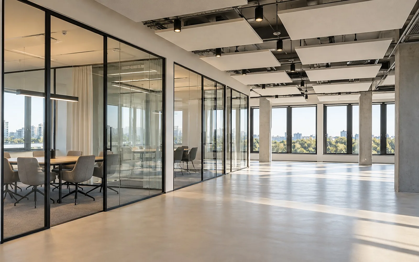 Büroausbau: leere Büroetage mit Glastrennwänden, Akustikdeckensegeln und großen Fenstern