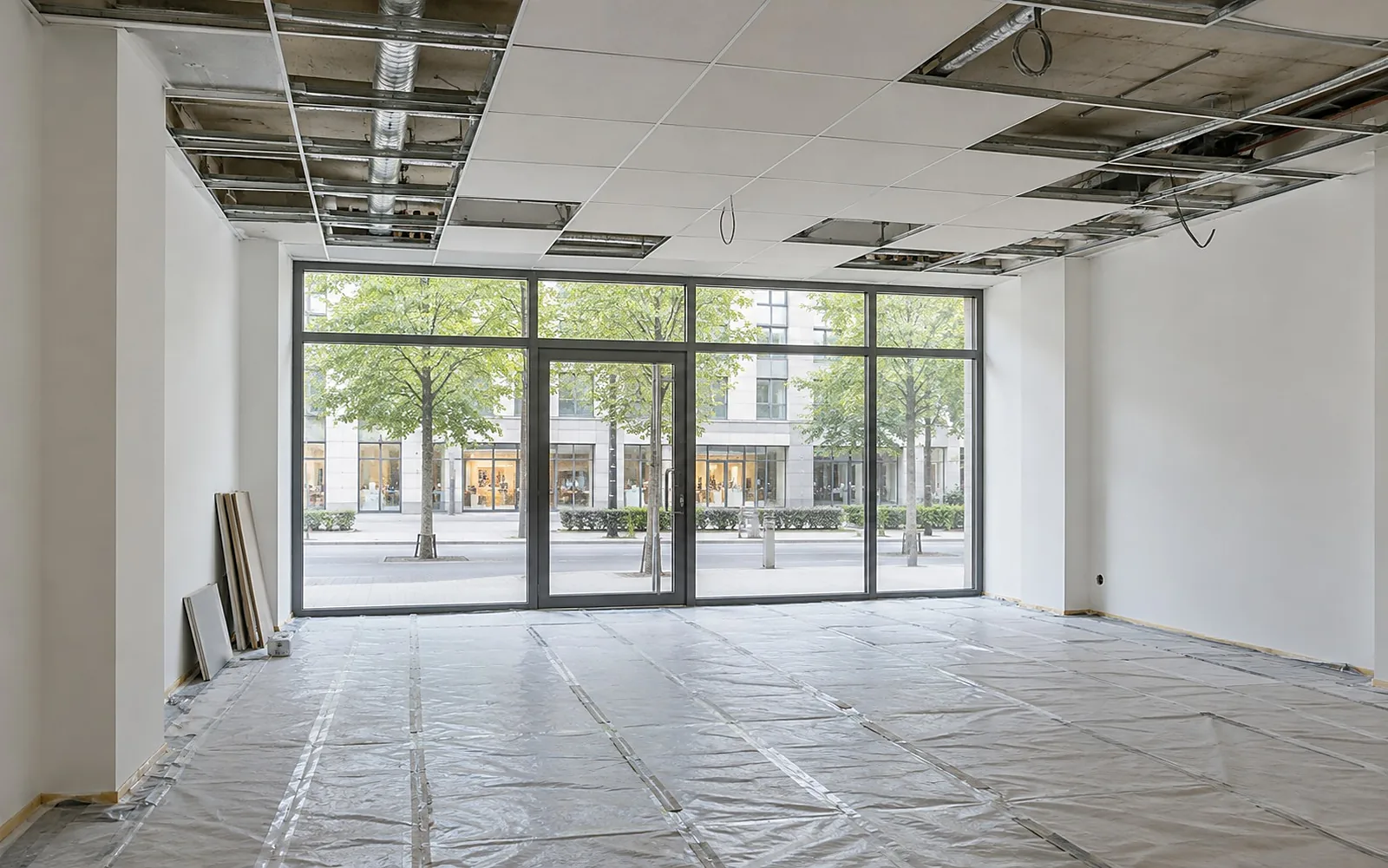 Ladenbau: leeres Ladenlokal mit Schaufensterfront im Ausbau, neue Wände und halb fertige Decke